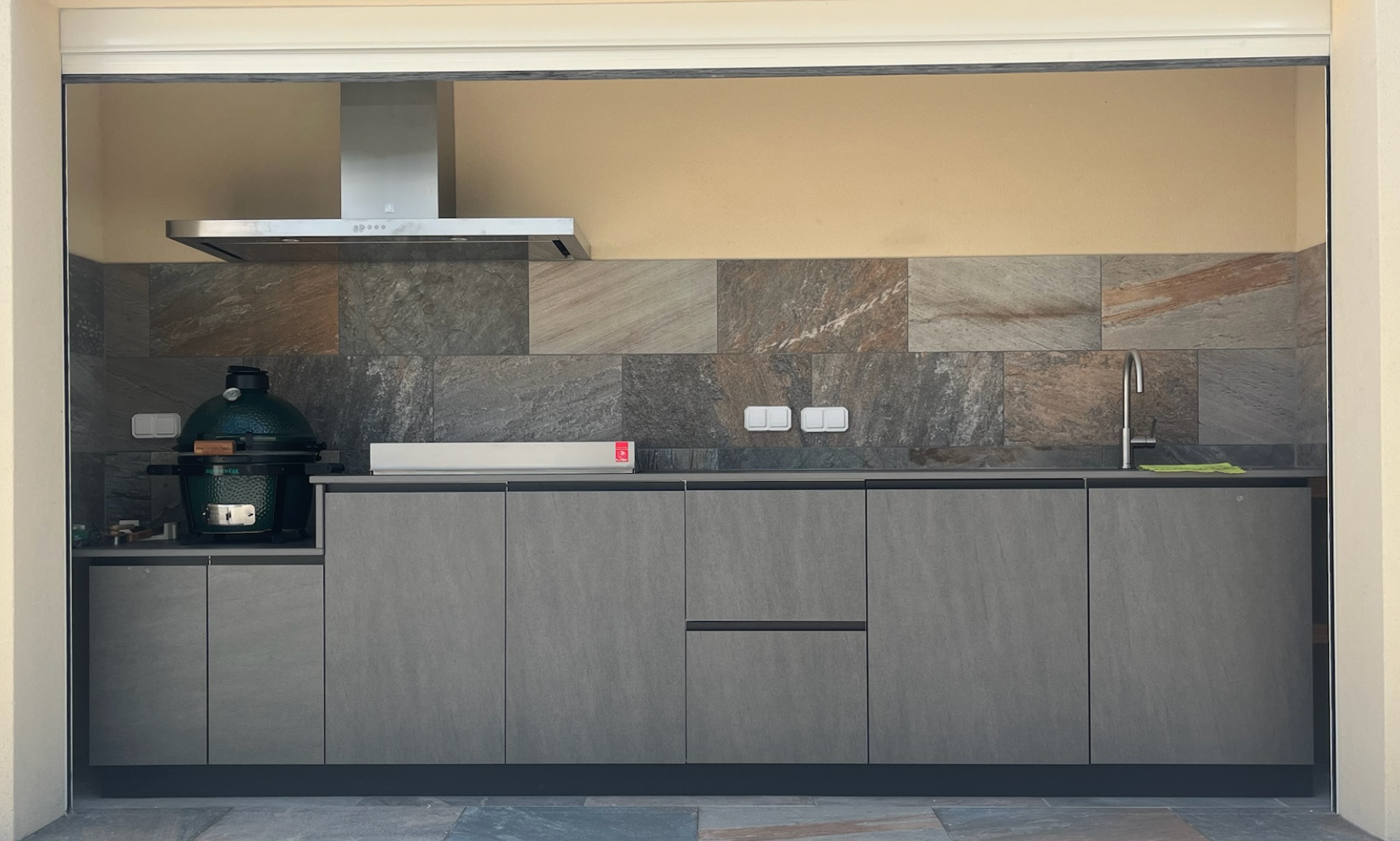 cuisine d'extérieur avec plancha intégré encastré kamado mitigeur évier inox hotte aspirante couverte avec toit