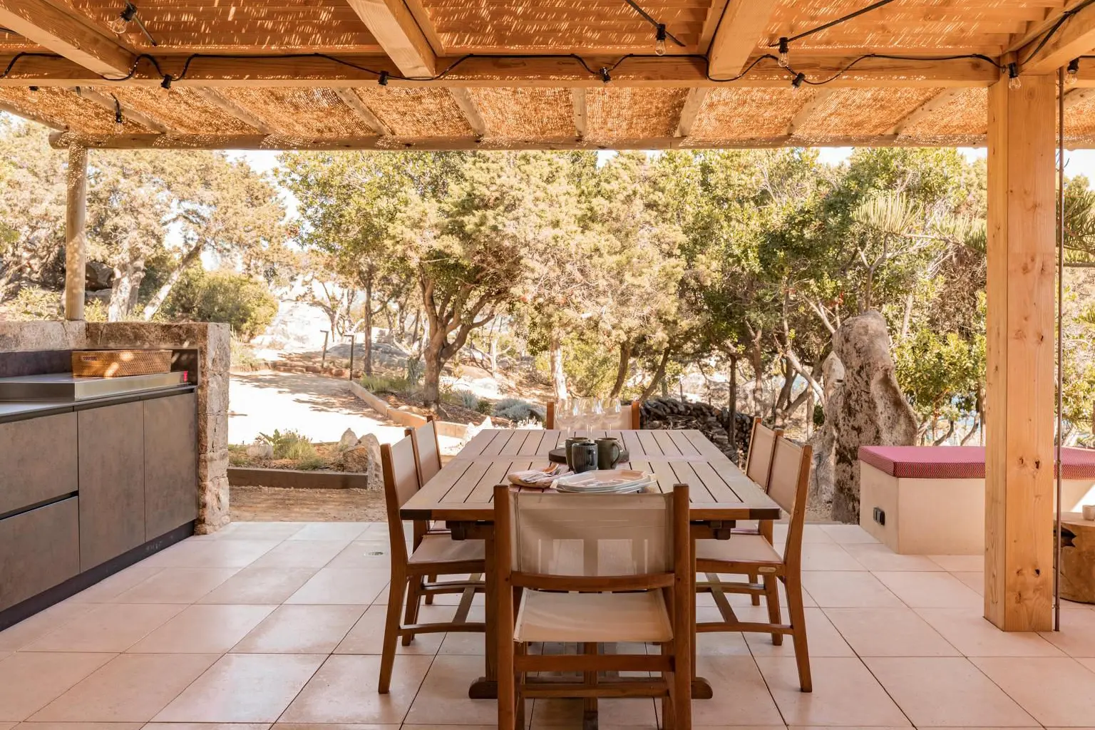 cuisine d'été meuble cuisine extérieure avec plancha table à manger chaises pergola organique canisse Corse France contemporain style provençale