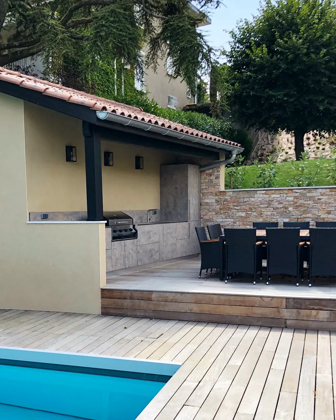 cuisine d'extérieur cuisinedété sur mesure avec plancha à poser évier mitigeur inox avec toit couvert table à manger piscine