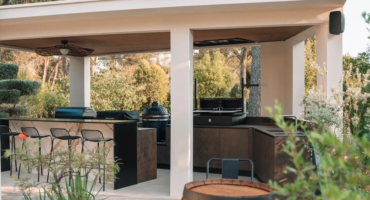 cuisinedété cuisine extérieure sur mesure en angle avec ilôt comptoir barplancha kamado rotissoire barbecue couvert pergola sous toit montpellier Hérault Occitanie